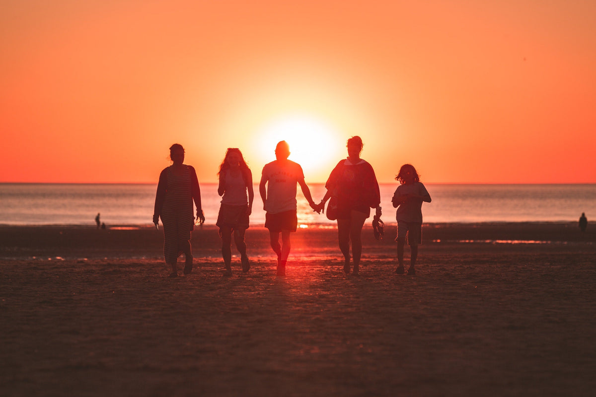 People walking towards a sunset